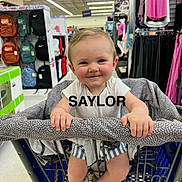 Saylor joined the competition — help win amazing prizes! baby, backpacks, child, clothing, cute, foot, footwear, handle, happy, indoor, infant, person, rack, retail, retail_display, shopping_cart, shorts, smile, store, white_shirt
