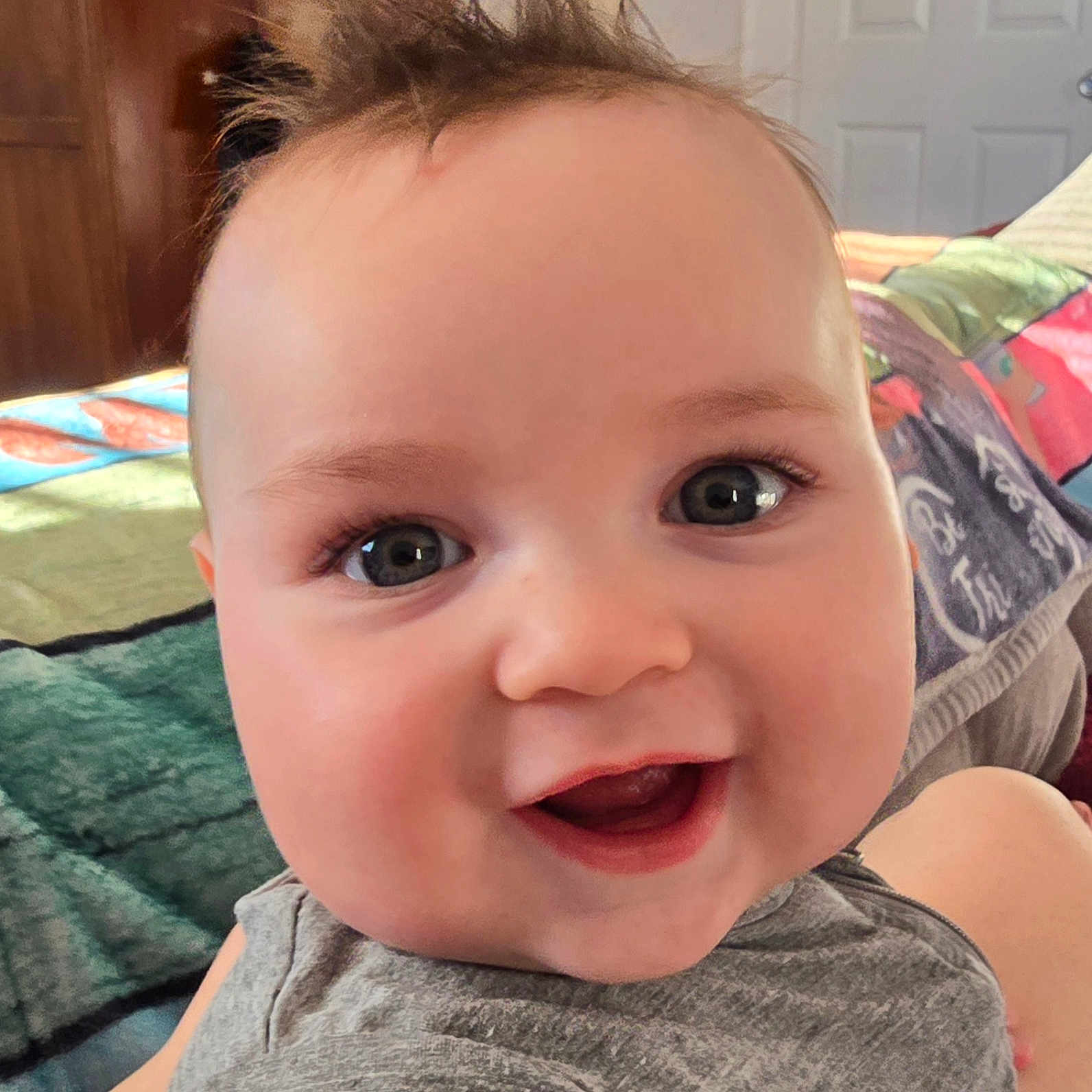 Levi is registered to the contest to win money with this photo: baby, smiling, face, child, hair, indoor, closeup, eyes, expression, joy, happy, skin, person, clothing, background, blanket, door, head, portrait, infant