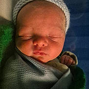 Samuel is registered to the contest to win money with this photo: newborn, baby, sleeping, blanket, knitted_cap, infant, closeup, wrapped, peaceful, soft_lighting, face, cute, young_child, indoors, portrait, baby_clothing, resting, newborn_baby, swaddled, sleep