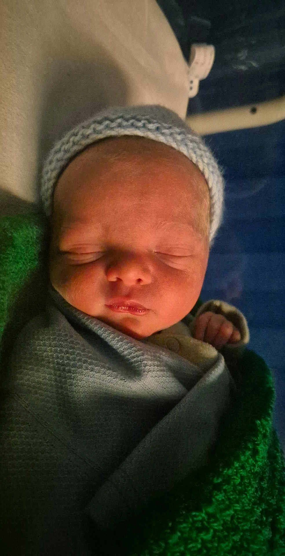Samuel is registered to the contest to win money with this photo: newborn, baby, sleeping, blanket, knitted_cap, infant, closeup, wrapped, peaceful, soft_lighting, face, cute, young_child, indoors, portrait, baby_clothing, resting, newborn_baby, swaddled, sleep