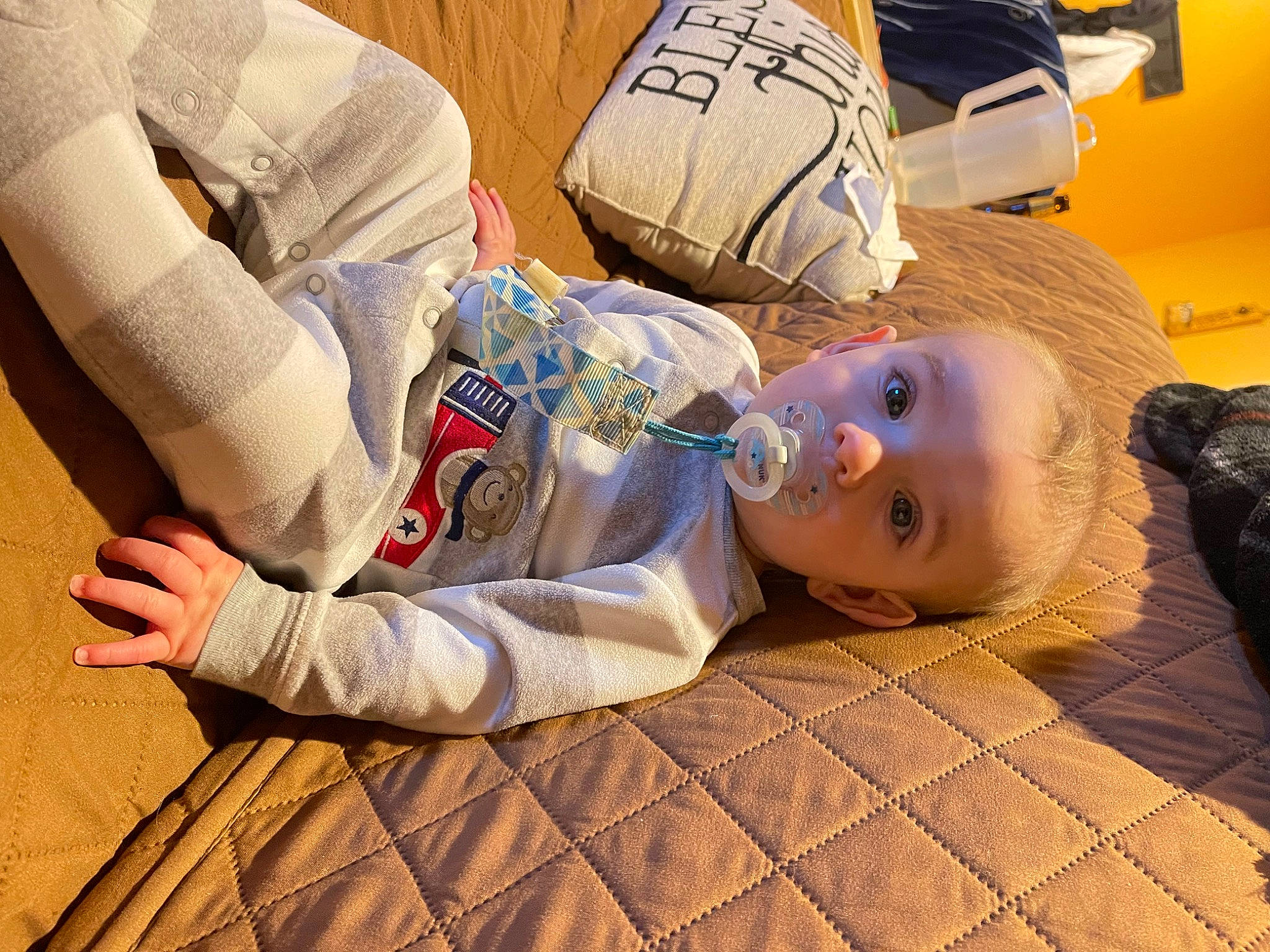 Logan is registered to the contest to win money with this photo: baby, baby_toddler_clothing, bedding, bedtime, child, comfort, floor, flooring, fun, happy, human_leg, linens, nap, person, room, sitting, skin, sleep, textile, toddler