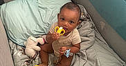 Douglas joined the competition — help win amazing prizes! baby, infant, playpen, blanket, pillow, toy, plush_toy, pacifier, teething_toy, child, indoors, cute, sitting, soft, comfort, looking_at_camera, clothing, smiling, face, person