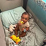 baby, infant, playpen, blanket, pillow, toy, plush_toy, pacifier, teething_toy, child, indoors, cute, sitting, soft, comfort, looking_at_camera, clothing, smiling, face, person