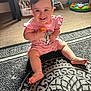 baby, books, carpet, child, colorful, cute, floor, furniture, happy, home, indoor, infant, patterned_rug, person, pink_clothing, playroom, short_hair, sitting, smiling, toy