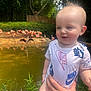 baby, child, person, hand, pond, water, flamingo, bird, nature, greenery, tree, grass, outdoor, daylight, clothing, onesie, smile, face, animal, wildlife