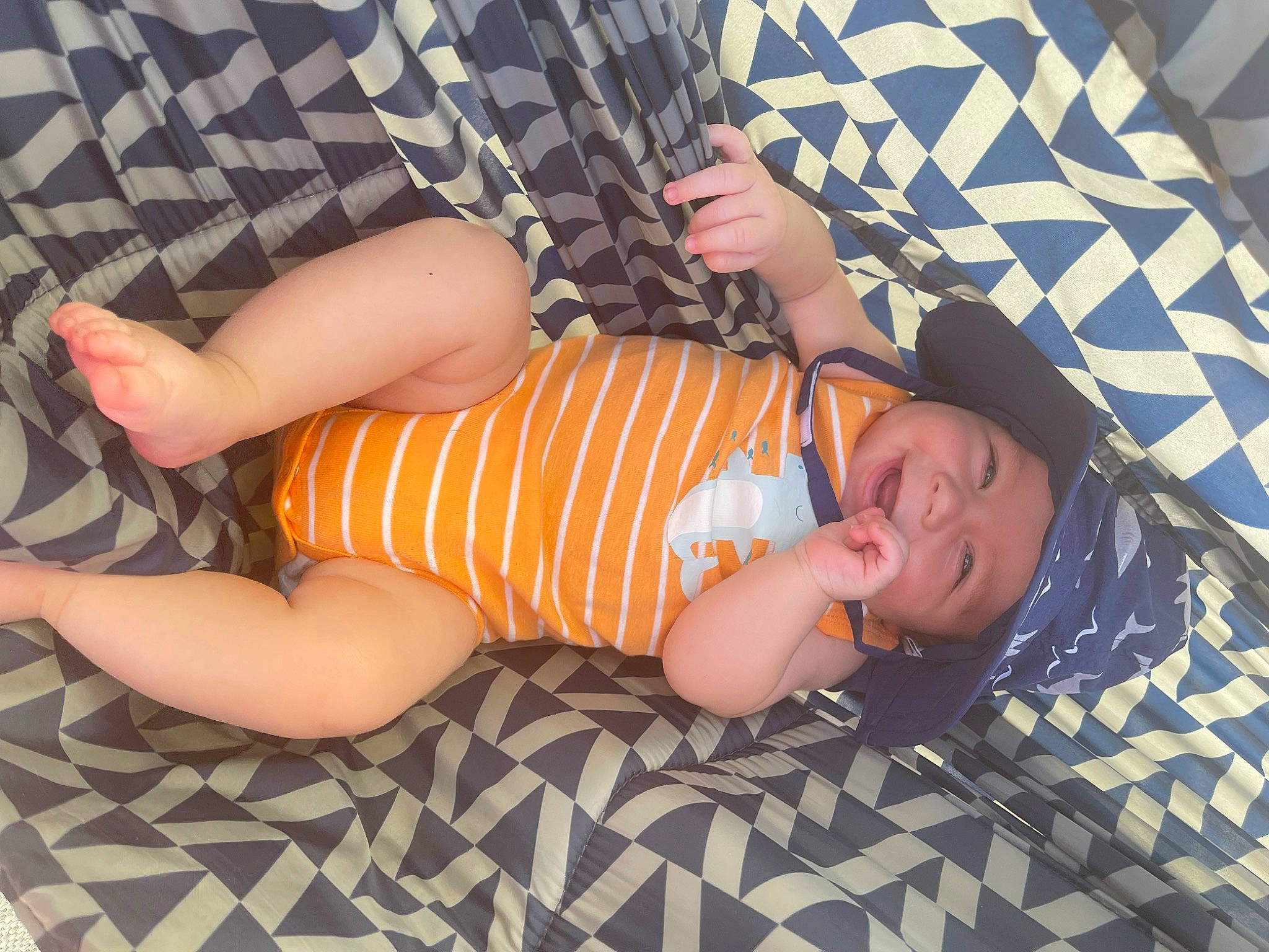 Keegan joined the competition — help win amazing prizes! baby_toddler_clothing, child, comfort, facial_expression, finger, flooring, foot, fun, grass, headwear, human_leg, knee, lap, nail, pattern, person, sitting, sleeve, sock, thigh