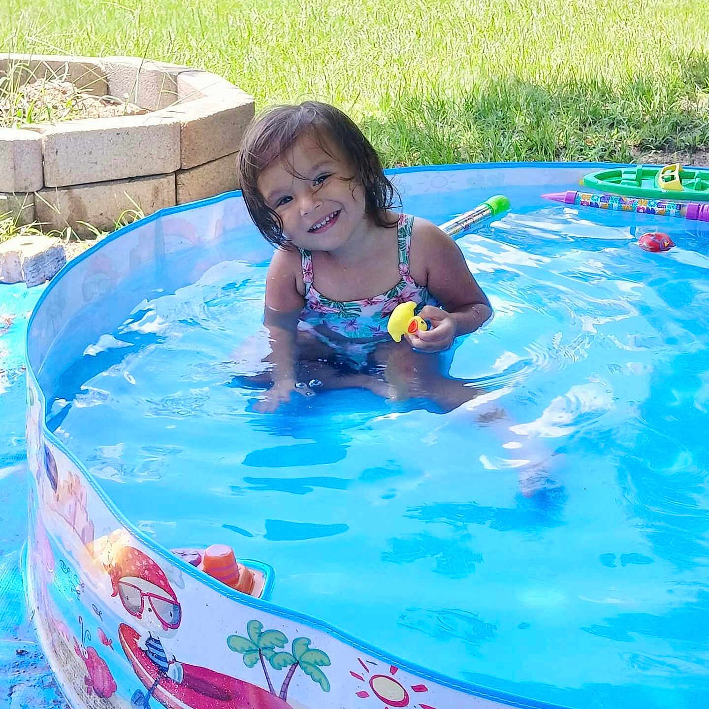 Kellcey joined the competition — help win amazing prizes! child, face, grass, greenery, happy, inflatable_pool, outdoor, person, plastic, play, pool, rubber_duck, smile, splash, summer, sunlight, swimsuit, toddler, toy, water