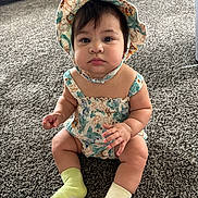 Lyla joined the competition — help win amazing prizes! baby, child, sitting, hat, romper, carpet, indoor, cute, sock, mismatched_socks, curious, portrait, infant, chubby_cheeks, person, clothing, floor, closeup, young_child, headwear