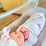 Genesis joined the competition — help win amazing prizes! newborn, baby, sleeping, blanket, pink_bow, crib, swaddle, headwear, infant, peaceful, closeup, indoors, soft_lighting, cute, hands, face, rest, cozy, wrapped, portrait