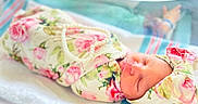 Genesis is registered to the contest to win money with this photo: baby, child, closeup, cute, floral_blanket, headband, hospital_bassinet, human, indoors, infant, newborn, peaceful, pearl_necklace, pink, portrait, resting, sleeping, soft_lighting, white, wrapped