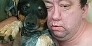 Blue is registered to the contest to win money with this photo: man, dog, bed, pillow, cuddle, relaxing, indoor, sleepy, pet, companion, face, paw, skin, fur, blanket, closeup, rest, casual, friendship, expression
