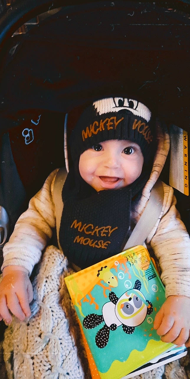 Drake a rejoint le concours — aidez-le/la à gagner de superbes lots ! baby, baby_products, baby_toddler_clothing, baseball_cap, beanie, cap, cheek, child, fashion_accessory, fun, happy, headwear, hoodie, knit_cap, person, play, room, sitting, sleeve, smile
