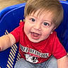 baby, blue_eyes, casual_clothing, child, cute, expression, floor, footwear, furniture, happy, indoor, jeans, light_brown_hair, person, playful, portrait, red_shirt, shopping_basket, smiling, toddler