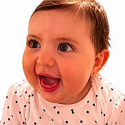 Harley joined the competition — help win amazing prizes! baby, child, smiling, happy, face, portrait, polka_dot, shirt, heart, hair, ponytail, cute, infant, young_child, person, sitting, indoors, closeup, bright, expression