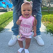 Tyliah joined the competition — help win amazing prizes! baby, child, smiling, standing, sidewalk, adult, hands, legs, pink_clothing, headband, outdoor, grass, car, shoes, happy, support, person, sunny, cute, portrait