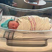 Ethan joined the competition — help win amazing prizes! newborn, baby, swaddled, hospital, bassinet, blanket, hat, sleeping, infant, person, indoor, resting, healthcare, cute, portrait, wrapped, toddler, child, nursery, young