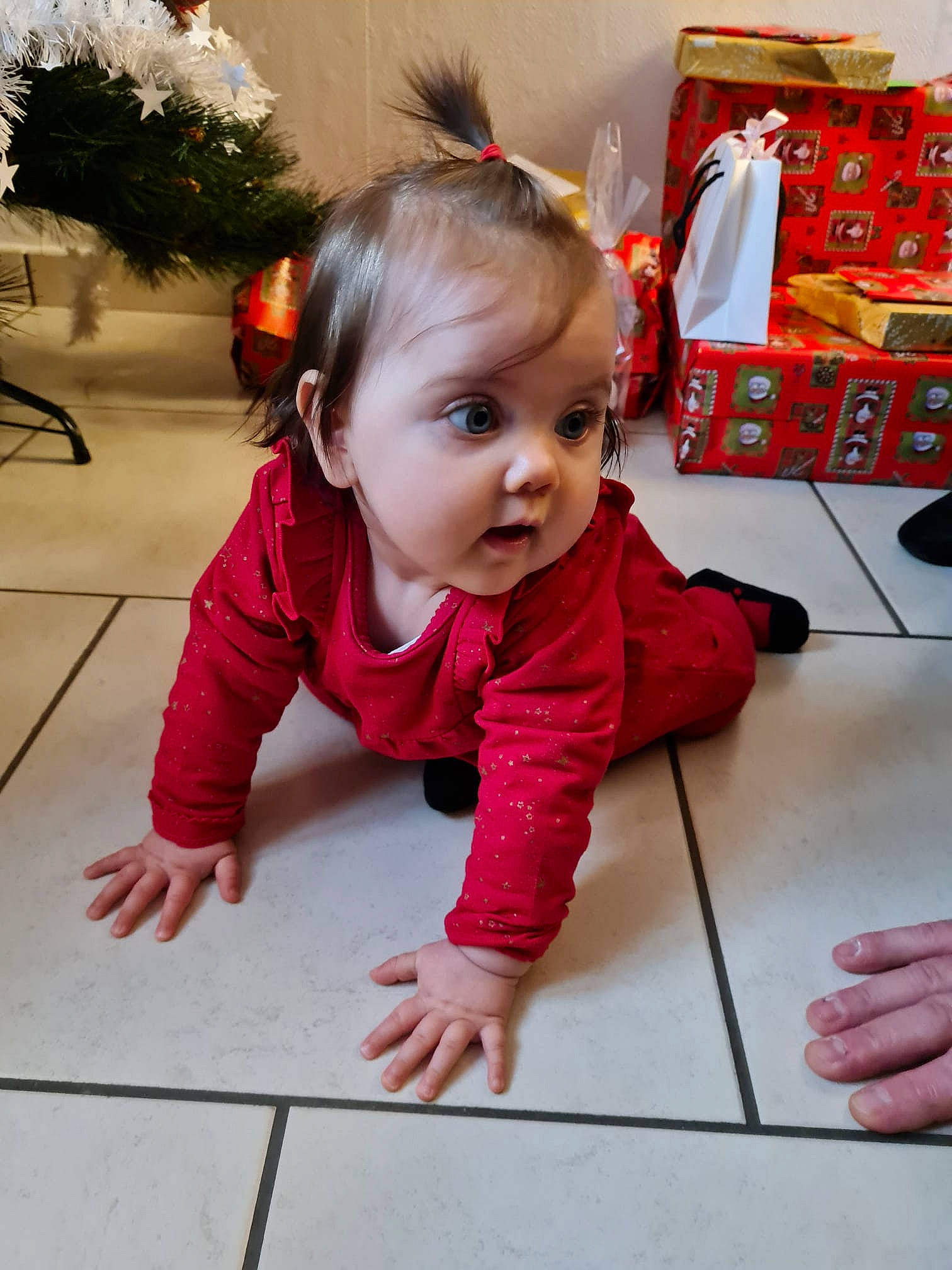 Méline a rejoint le concours — aidez-le/la à gagner de superbes lots ! baby_toddler_clothing, child, christmas, christmas_eve, event, eye, floor, flooring, fun, happy, hardwood, holiday, person, plant, room, sitting, skin, standing, surprise, toddler