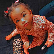 Paris is registered to the contest to win money with this photo: toddler, child, pigtails, curious, indoor, leopard_print, pouch, black_surface, clothing, patterned_outfit, person, cute, looking_up, baby, hands, foot, sitting, bright_eyes, hair_ties, young_child