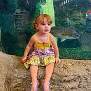 Oceana joined the competition — help win amazing prizes! child, toddler, girl, portrait, aquarium, fish, underwater, colorful_dress, sitting, rock, outdoor, indoor, wildlife, marine_life, glass_tank, curious, brown_hair, smiling, sandals, family_photo