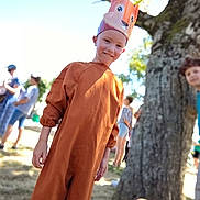 Menzo participe au concours pour gagner de l'argent avec cette photo : blurred_background, bracelet, brown_clothing, celebration, child, costume, crown, daytime, festival, fox, grass, hand, happy, nature, outdoor, people, portrait, smile, sunlight, tree