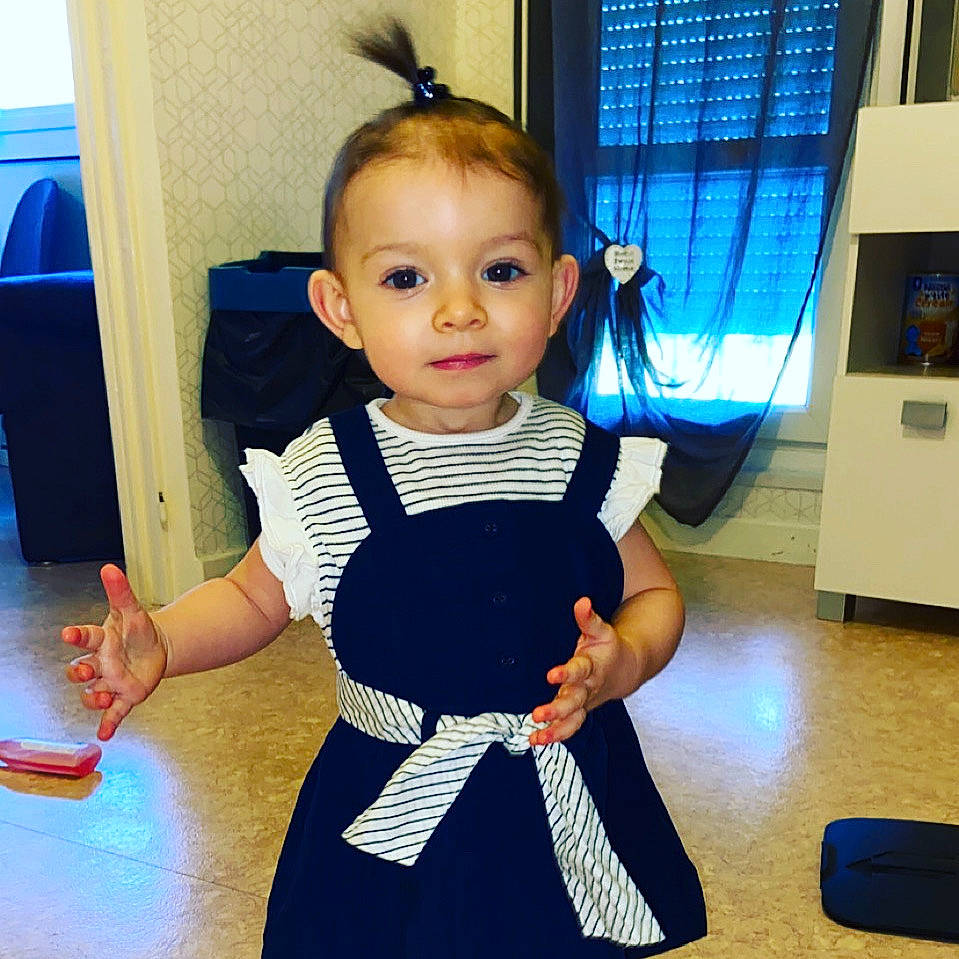 Akira participe au concours pour gagner de l'argent avec cette photo : baby, baby_toddler_clothing, black_hair, blue, dress, electric_blue, eye, face, flooring, fun, hair, happy, head, joy, person, sleeve, sportswear, standing, thumb, toddler