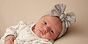 Kenza a rejoint le concours — aidez-le/la à gagner de superbes lots ! baby, bow, child, clothing, cute, expression, face, headband, indoors, infant, lying_down, minimalistic, neutral_background, newborn, peaceful, portrait, resting, skin, small_hands, soft_lighting