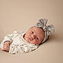 Kenza a rejoint le concours — aidez-le/la à gagner de superbes lots ! baby, infant, headband, bow, clothing, face, skin, lying_down, portrait, expression, newborn, soft_lighting, minimalistic, neutral_background, cute, child, indoors, peaceful, small_hands, resting