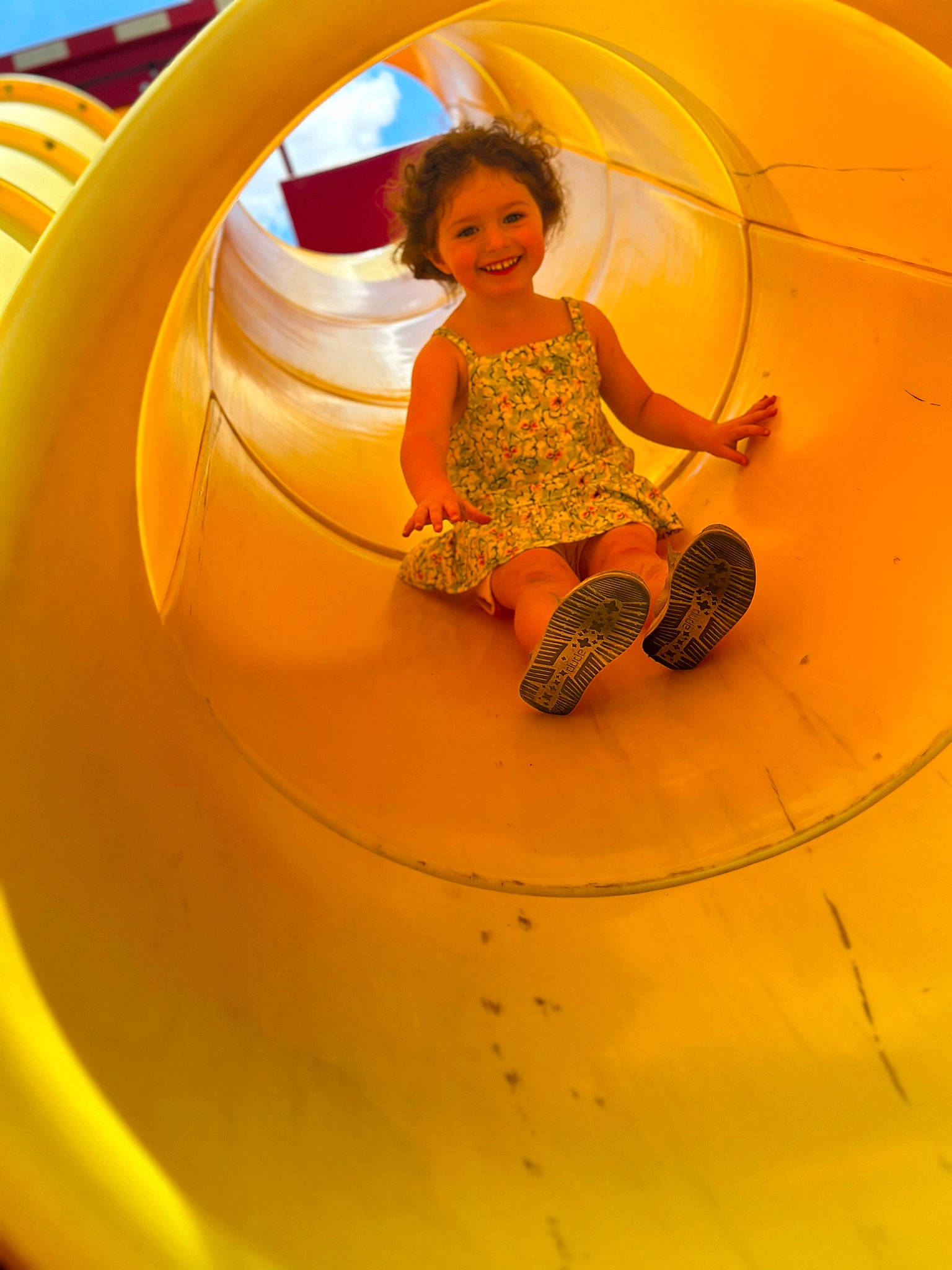 Lillian is registered to the contest to win money with this photo: automotive_exterior, automotive_tire, baby_toddler_clothing, child, chute, circle, city, fun, happy, joy, leisure, motor_vehicle, outdoor_play_equipment, person, play, playground, recreation, smile, t_shirt, toddler