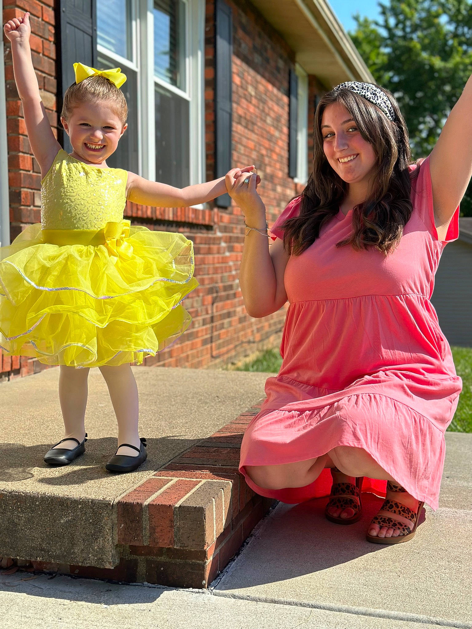 Lillian is registered to the contest to win money with this photo: child, costume, event, eyewear, fun, happy, house, human_leg, joy, leisure, magenta, person, pink, recreation, sandal, sitting, smile, street, summer, toddler