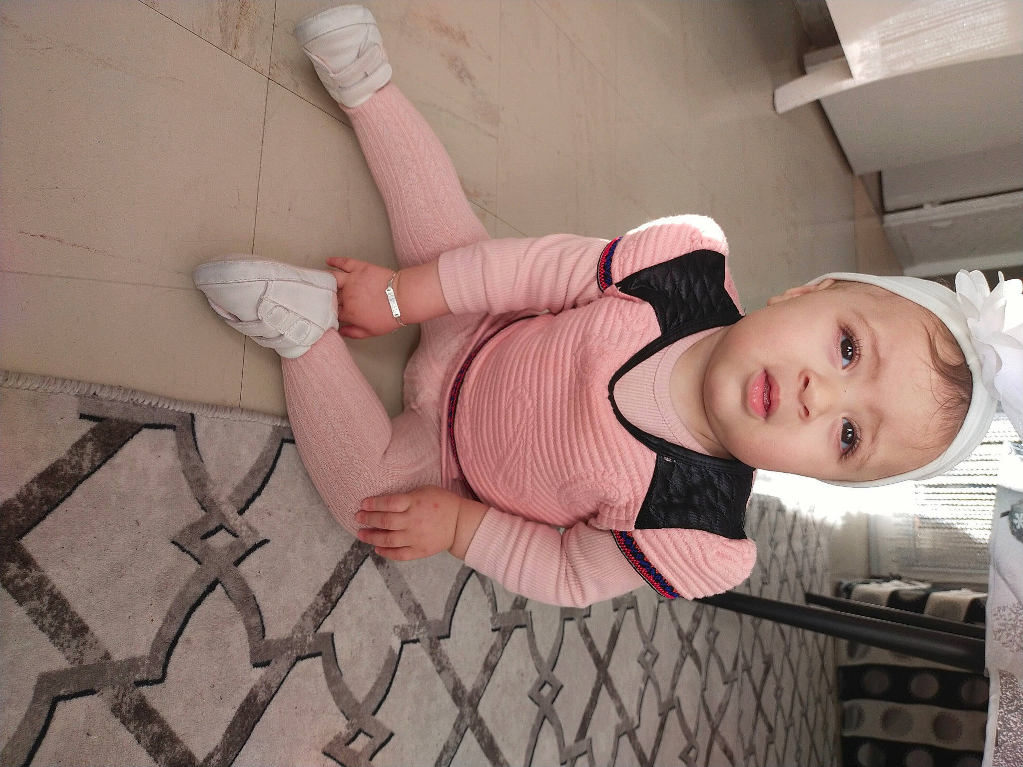 Afnen Stiti a rejoint le concours — aidez-le/la à gagner de superbes lots ! baby, baby_toddler_clothing, elbow, eyewear, flesh, foot, hat, human_leg, joint, knee, leg, pattern, person, pink, sandal, sitting, thigh, toddler, waist, wood
