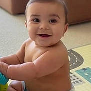 Mateo is registered to the contest to win money with this photo: baby, child, smile, happy, sitting, indoor, play_mat, toy, cute, chubby, face, infant, skin, person, young_child, expression, cheeks, eyes, arms, legs