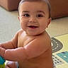 Mateo is registered to the contest to win money with this photo: arms, baby, child, childhood, cute, eyes, face, floor, happy, home, indoor, infant, legs, mouth, play_mat, shorts, sitting, skin, smiling, toy