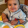 Mateo joined the competition — help win amazing prizes! baby, child, smiling, striped_shirt, baseball_jersey, watch, walker, toy, indoor, happy, face, person, furniture, stairs, wood_floor, hand, seat, cute, infant, home