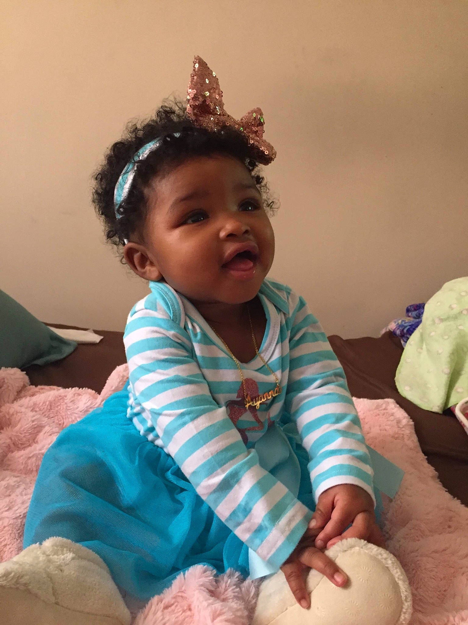 Ayanna is registered to the contest to win money with this photo: baby, baby_toddler_clothing, cheek, child, ear, fashion_accessory, fun, hair_accessory, head, headband, headgear, headpiece, person, play, sitting, skin, smile, toddler