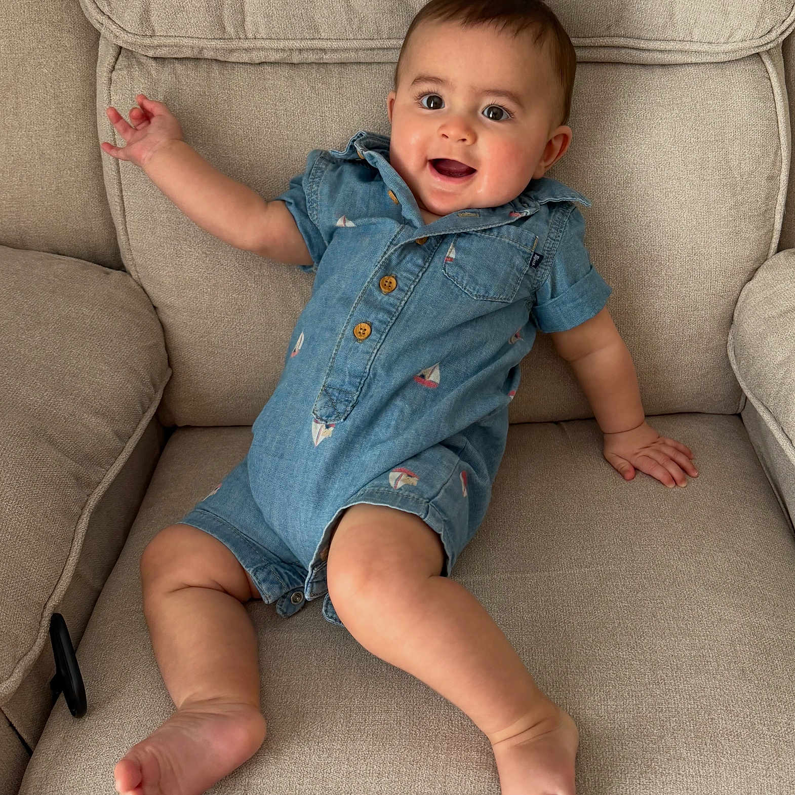 Jesse joined the competition — help win amazing prizes! baby, child, smiling, romper, blue_clothing, couch, furniture, indoor, person, happy, infant, cute, sitting, skin, foot, hand, head, face, eyes, expression