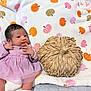 baby, infant, purple_dress, blanket, pumpkin_pattern, woven_pumpkin, cute, newborn, lying_down, soft_texture, autumn_theme, decor, cozy, indoor, small_hands, portrait, child, fabric, pattern, head