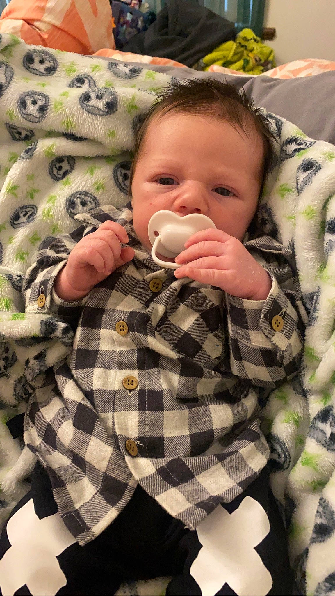 Braxley is registered to the contest to win money with this photo: baby, baby_toddler_clothing, cheek, child, comfort, eye, face, finger, grass, head, linens, military_camouflage, pattern, person, plaid, skin, sleeve, tartan, textile, thumb