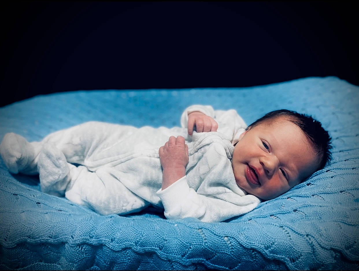 Braxley is registered to the contest to win money with this photo: baby, baby_toddler_clothing, bedtime, cheek, child, comfort, darkness, eye, flash_photography, grass, happy, linens, nap, person, portrait_photography, room, sitting, skin, sleep, sleeve