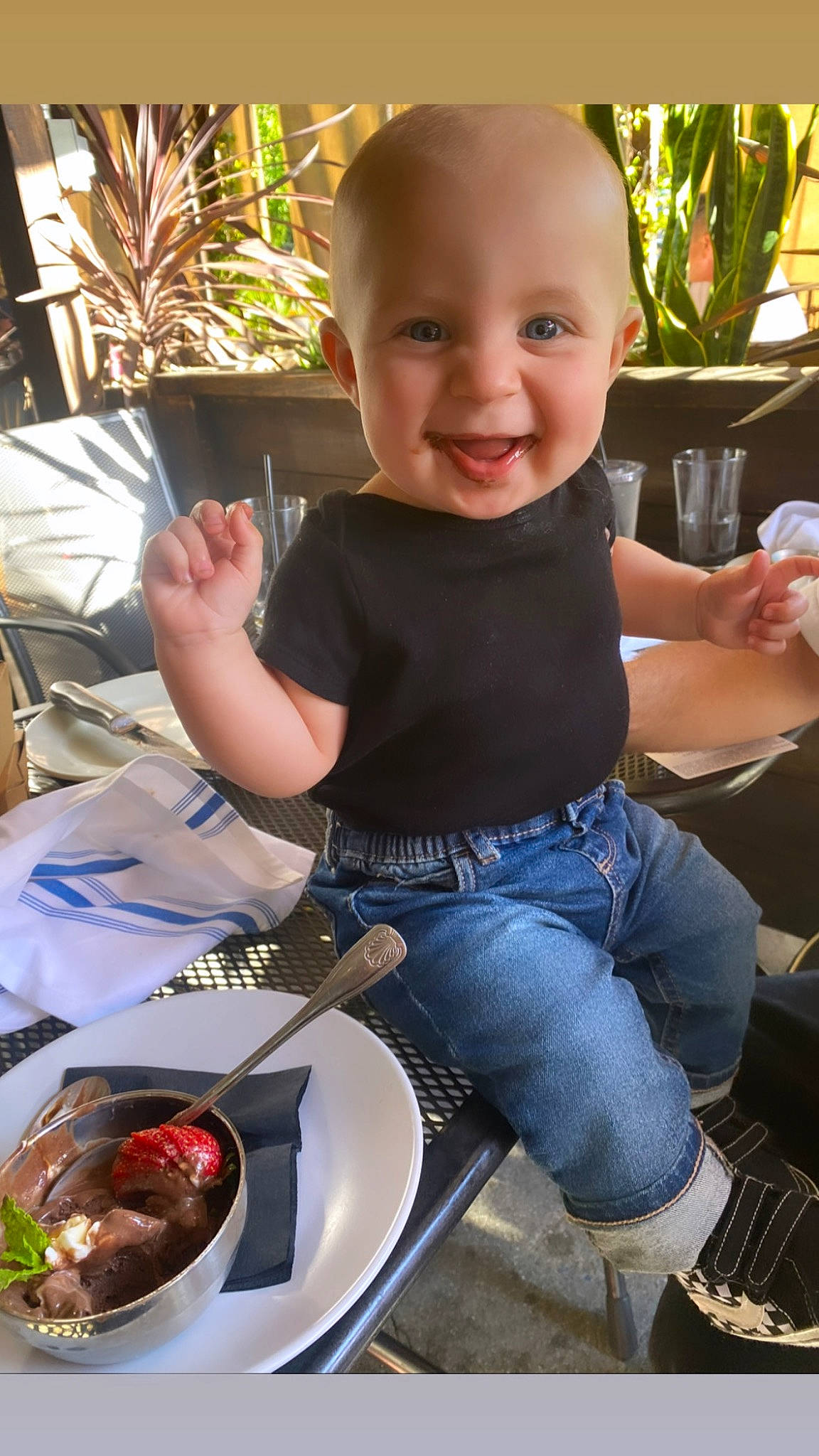 Jett is registered to the contest to win money with this photo: baby, baby_toddler_clothing, chair, child, cooking, food, fun, happy, houseplant, jeans, joy, leisure, person, plant, plate, recipe, sitting, smile, t_shirt, table