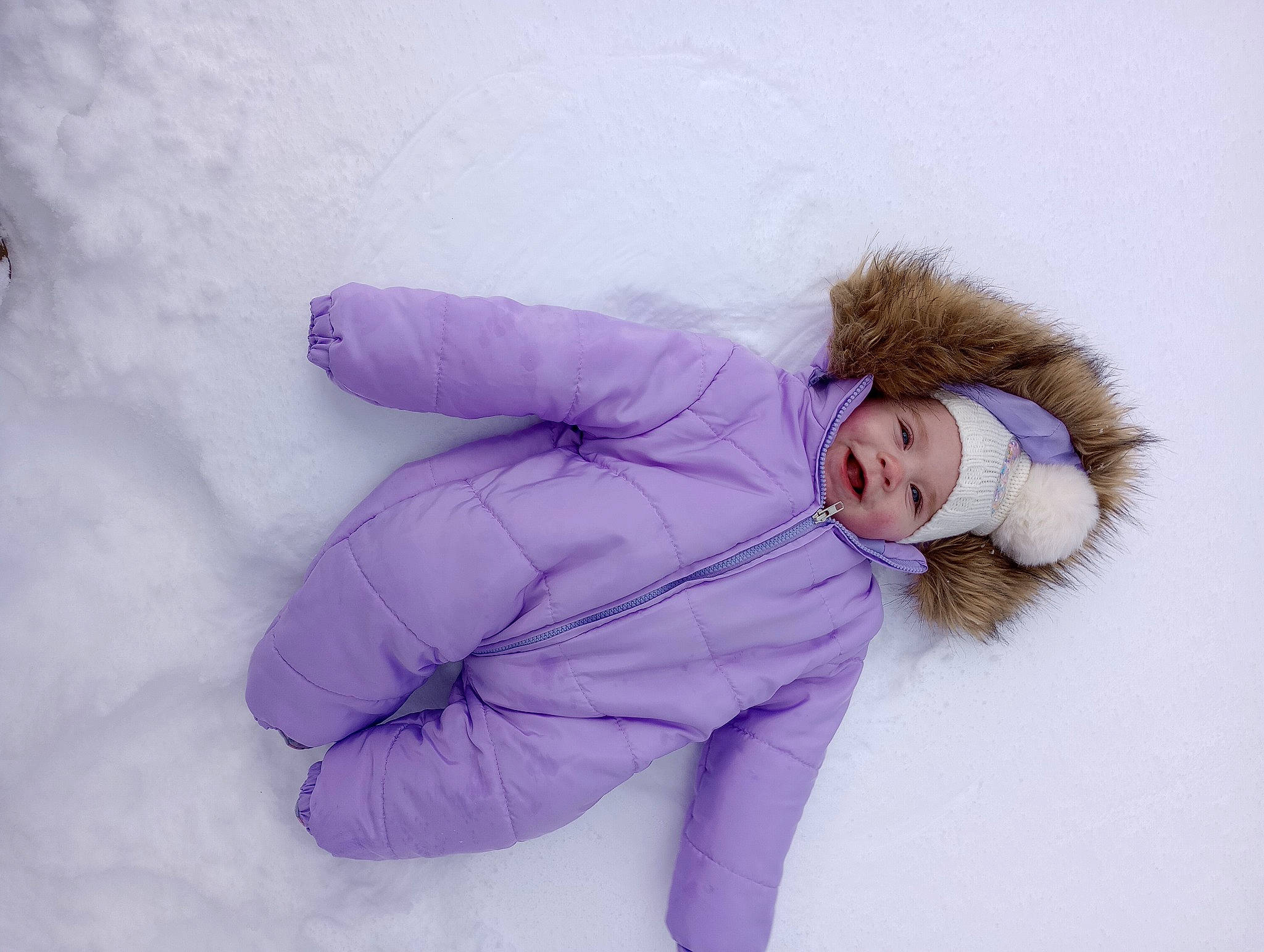 Nova is registered to the contest to win money with this photo: child, costume, freezing, fun, fur, fur_clothing, glove, happy, headwear, magenta, parka, person, playing_in_the_snow, purple, sitting, sleeve, snow, toddler, winter