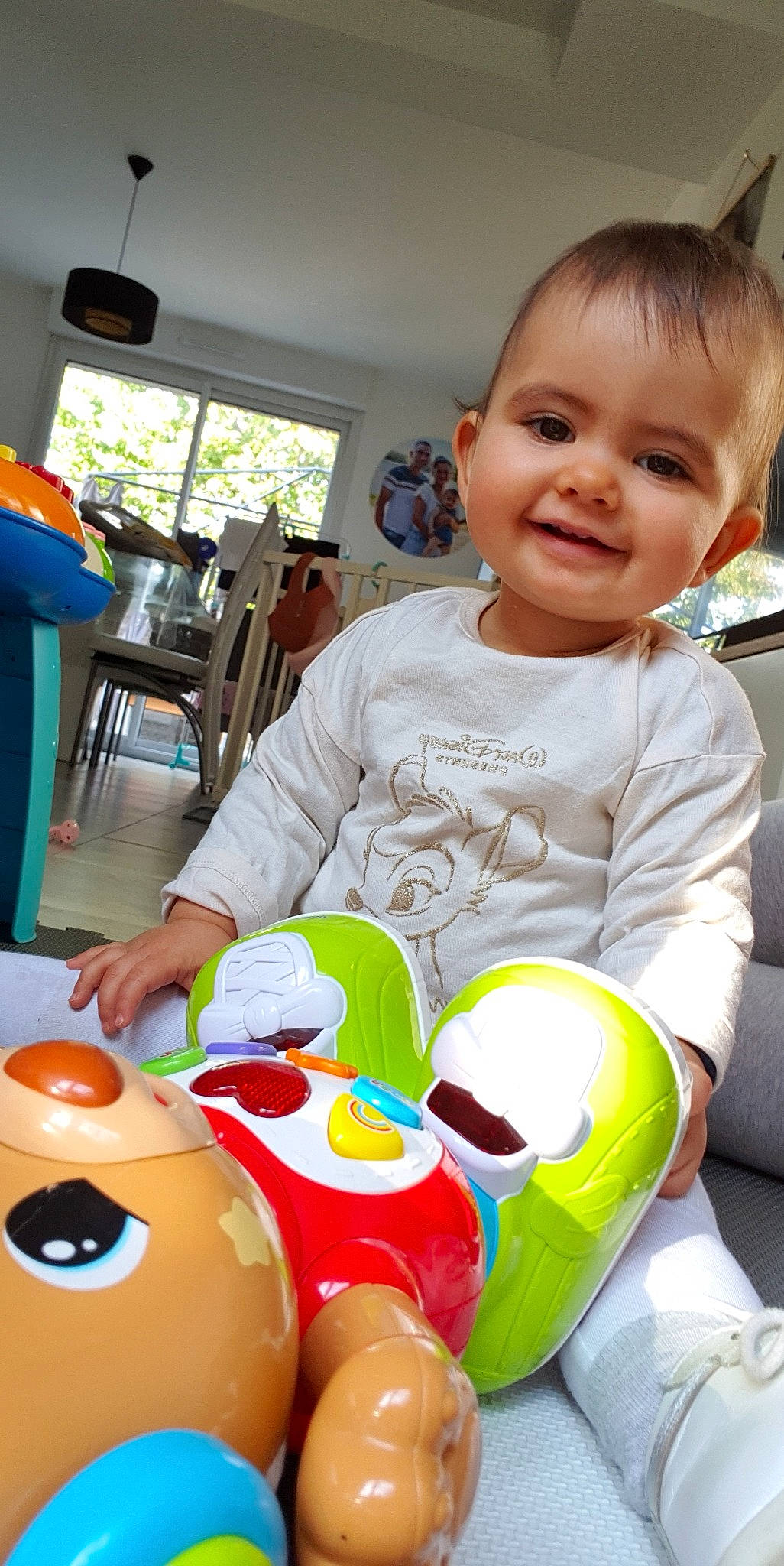 Elyana participe au concours pour gagner de l'argent avec cette photo : baby, baby_playing_with_toys, baby_toddler_clothing, chair, cheek, child, event, fun, happy, holiday, joy, person, plastic, room, sitting, skin, smile, t_shirt, toddler, toy