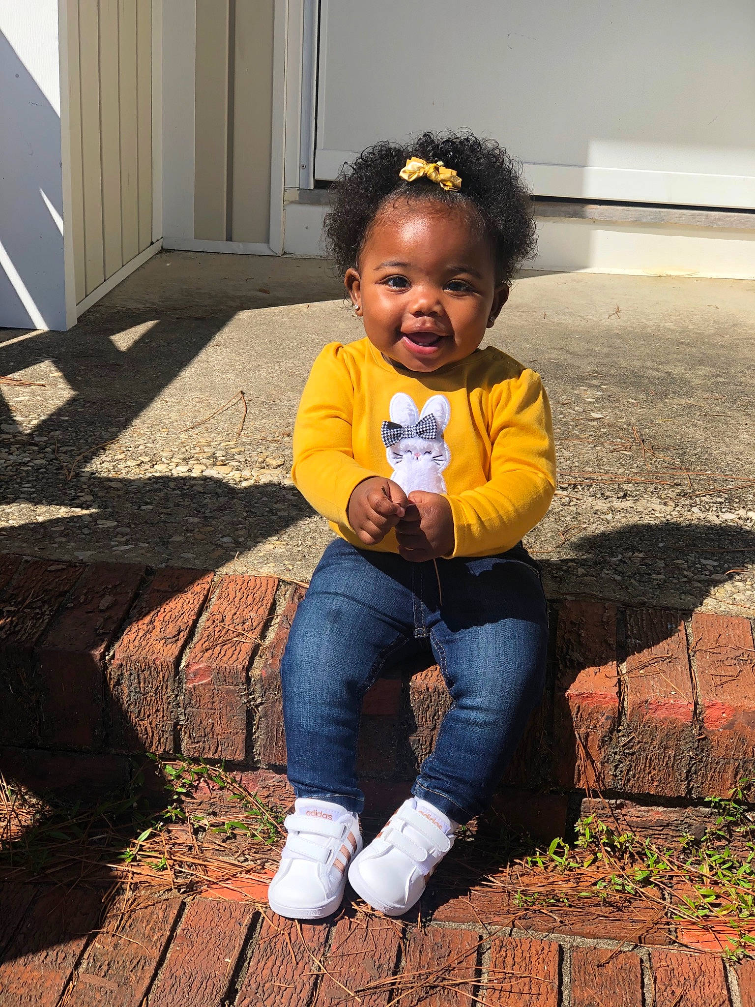 Melanie is registered to the contest to win money with this photo: baby_toddler_clothing, beauty, child, door, eye, flooring, fun, grass, happy, jeans, leg, people_in_nature, person, plant, road_surface, sitting, sneakers, standing, tints_and_shades, toddler