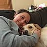 Benny Boo joined the competition — help win amazing prizes! person, dog, couch, smile, indoor, cozy, hug, pet, animal, casual, home, comfort, relaxation, happy, friendship, face, clothing, furniture, window, blanket