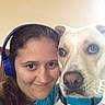 person, dog, headphones, blue_collar, indoor, selfie, smiling, face, pet, animal, closeup, brown_hair, light_brown_dog, casual, friendship, companion, portrait, candid, happy, human