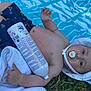 Hadriel participe au concours pour gagner de l'argent avec cette photo : baby, infant, pacifier, white_hat, blue_shorts, towel, grass, outdoor, summer, bottle, cartoon, cute, lying_down, child, bare_chest, hand, foot, relaxing, sun_hat, playful