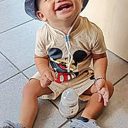Ousayd participe au concours pour gagner de l'argent avec cette photo : toddler, child, smiling, baby, hat, bucket_hat, mickey_mouse, tshirt, sitting, floor, tile_floor, baby_bottle, shoes, casual_clothing, indoors, happy, cute, young_child, person, playful