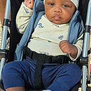 Chosen joined the competition — help win amazing prizes! baby, child, infant, stroller, portrait, face, eyes, hat, bear_hat, clothing, blue_outfit, jacket, pants, shoes, harness, sitting, outdoor, sunlight, pavement, smiling