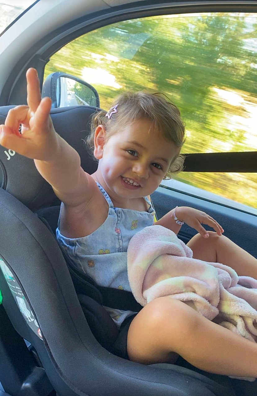Chiara a rejoint le concours — aidez-le/la à gagner de superbes lots ! toddler, child, car_seat, smile, dimples, blanket, hair_clip, window, car_interior, seatbelt, happy, gesture, summer_clothing, curly_hair, playful, portrait, sitting, outdoor_light, travel, young_child
