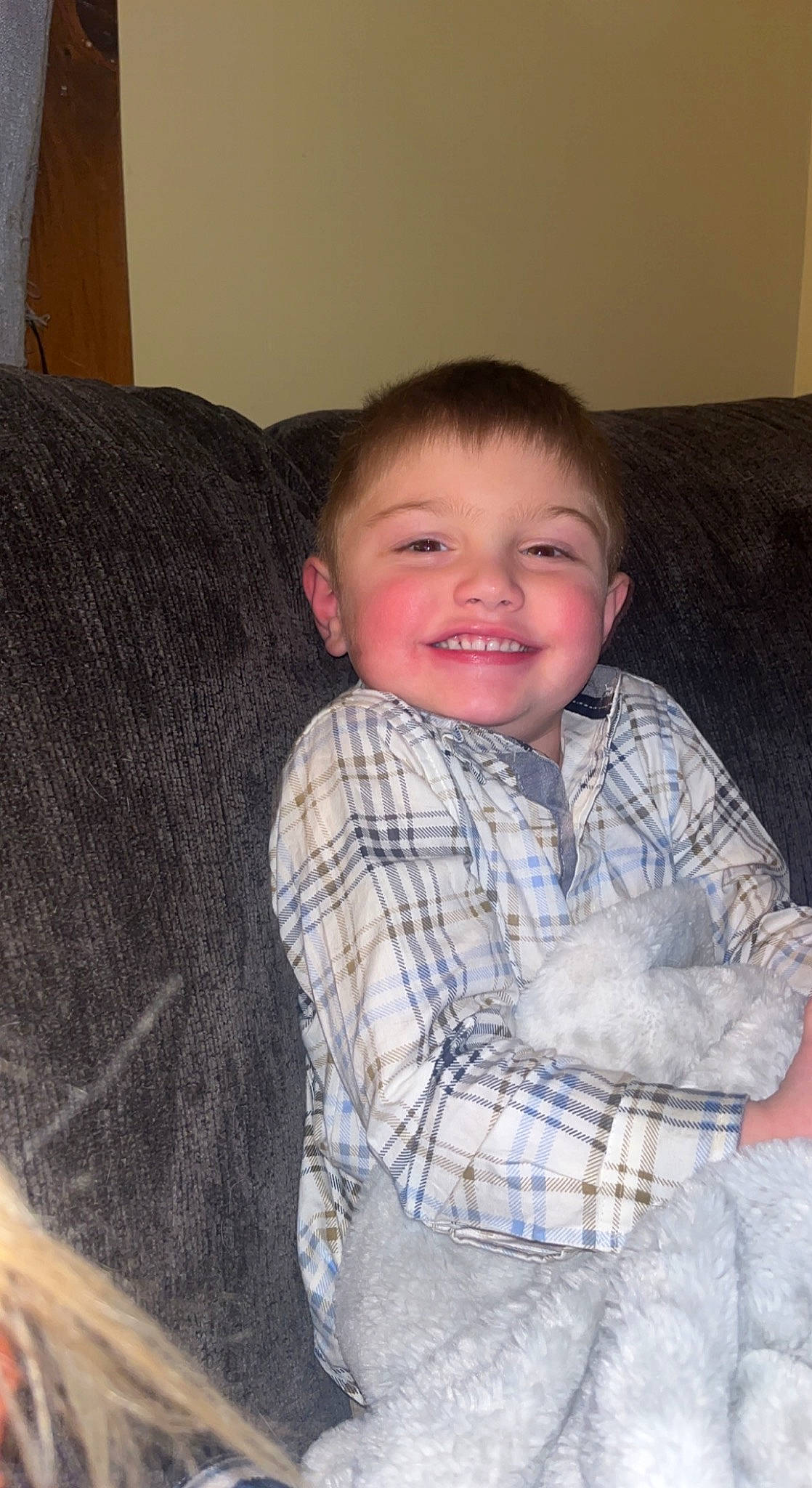 Logan joined the competition — help win amazing prizes! cheek, comfort, couch, eye, face, floor, hair, head, human_body, iris, joy, lap, leg, mammal, nose, person, plaid, skin, sleeve, smile