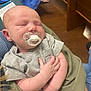 Lucas is registered to the contest to win money with this photo: baby, infant, sleeping, pacifier, blanket, arms, hands, clothing, indoor, wooden_floor, person, child, closeup, peaceful, resting, casual, comfort, skin, head, portrait